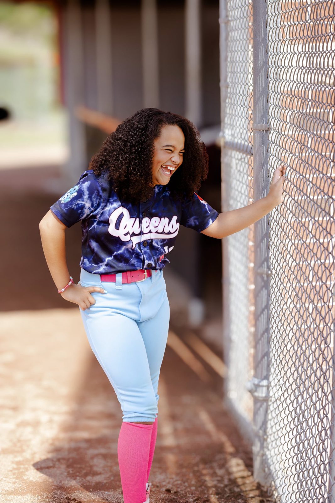 A young softball player in her team jersey