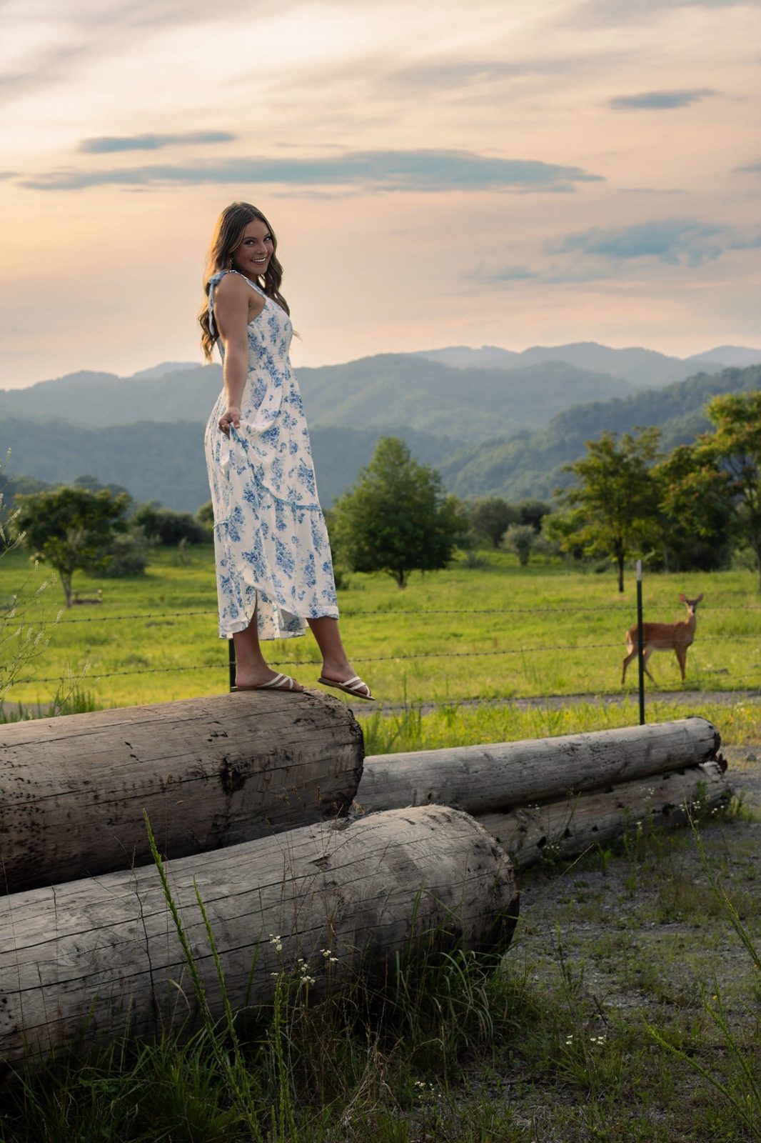 A senior standing in a mountain field at sunset